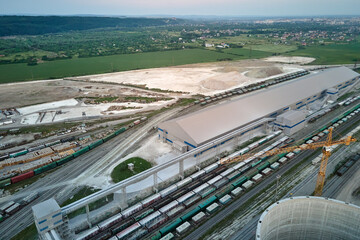 Aerial view of cargo train cars loaded with construction goods at mining factory. Railway...