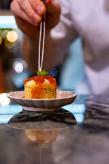 chef hand cooking Canape with brioche, butter, salmon red caviar.