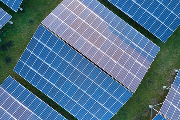 Aerial view of large sustainable electrical power plant with rows of solar photovoltaic panels for...