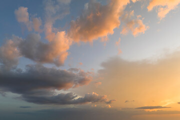Colorful evening landscape with soft pastel coloured clouds on watercolor tinted sunset sky. Abstract nature background