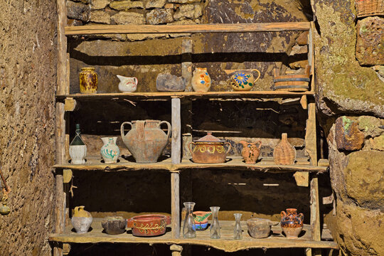 old wooden shelf with vintage pottery in house of the ancient abandoned village Celleno, Viterbo, Lazio, Italy