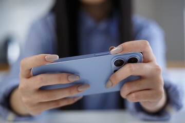 Gamer girl plays online game on smartphone. Young female playing videogames on gadget