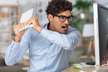 angry businessman breaking his computer - obrazy, fototapety, plakaty