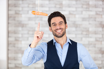 businessman pointing at a dangling carrot