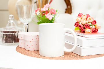 A white blank coffee mug standing out on a rounded mat with some decorations placed around it
