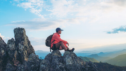 Happy tourists on top of mountain at sunset outdoors during summer hiking