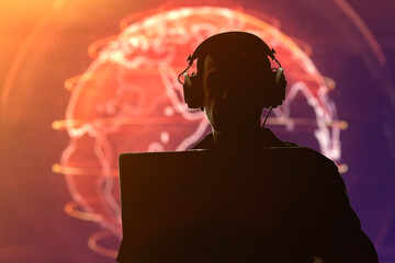 Silhouette of a military man in headphones at a laptop against the background of a glowing globe, contour lighting. Concept: collection of confidential information, surveillance and control of people. - obrazy, fototapety, plakaty