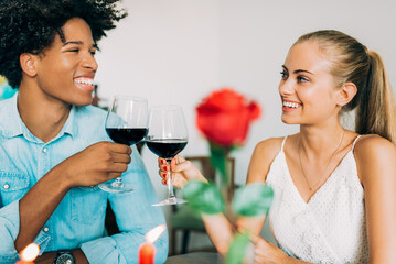 Happy young in love interracial couple having romantic dinner on