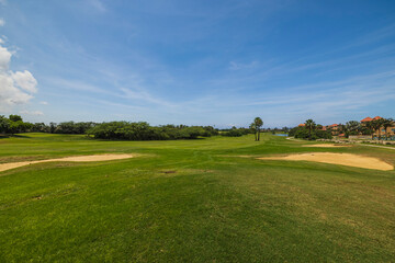 Gorgeous view of green grass golf field on background  blue sky. Aruba. 