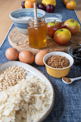 Ingredients to bake an apple cake spread out on a table 