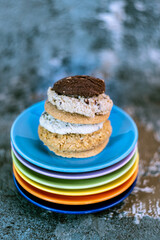 A pile of biscuits on a pile of colourful saucers