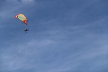 Fototapeta na wymiar Multi-colored parachute against the blue sky.