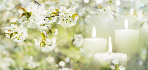 beautiful flowering tree in spring with burning white candles decoration on blurred garden background, beautiful contemplative atmosphere outside in nature