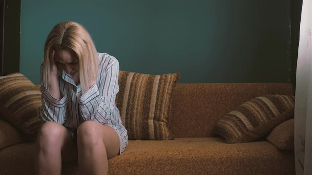 depressed woman with her hands in her hair distressed by a bad situation