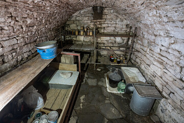 An old cellar with a shelf with a stone clamp.