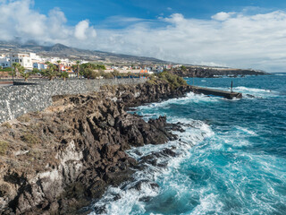 Obraz premium View of Alcala village, part of Guya de Isora municipality, with traditional architecture and sharp lava rock coast with small pier. Tenerife, Canary Islands, Spain