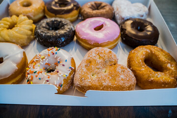 Close Up of Variety of Donuts in White Box on Table