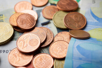 Euro bills and coins piled up on a table.
