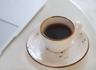 A mug with fragrant black coffee stands on the table