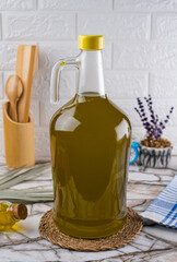 Kitchen Concept And Oil Filled  Big Glass Bottle. Olive Oil Carboy Bottle on Marble Background.
