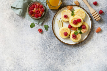 Homemade cottage cheese pancakes gluten free (syrniki, curd fritters) with berries on a stone background. Ricotta pancakes, morning breakfast table. View from above. Copy space.