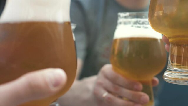 Cheers, Close-up two men in shirts toasting with beer at the bar counter