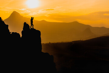 silhouette of mountaineer observing in the mountains