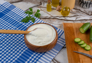 Traditional Greek or Turkish Yogurt Sauce in A Bowl On Marble Background. Kitchen Concept Tzatziki on Marble Floor. (Turkish name: Cacik)
