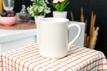 A white blank coffee mug on the top of a hand cloth with simple decorations arranged around it