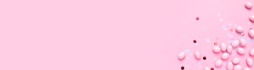 Bunch of  candy eggs  on pink background. Minimal Easter concept with copy space for text. Festive day backdrop. Flat lay style with minimalistic design. Template for banner or party invitation