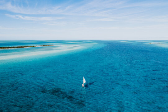 Aerial of Sailboat Sailing Between Islands in Turquoise Water