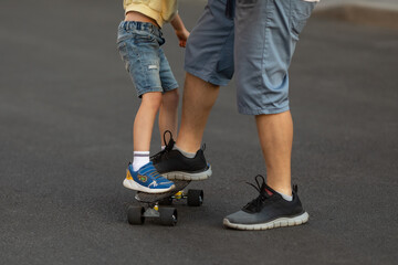 Closeup of dad and kid boy's feet on skateboard. skater riding a skateboard. view of a person riding on his skate. Sport and active life concept