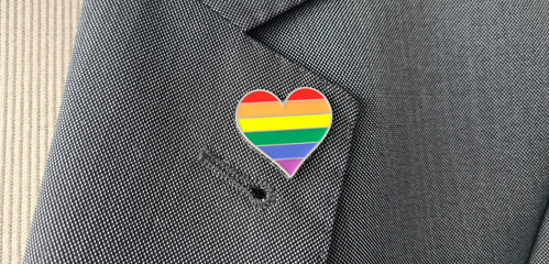 Metal badge with lgbt flag on lapel of man or woman suit