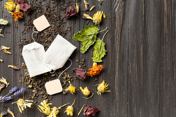 Dry green and black tea, tea bags, flower tea on a dark background top view close-up copy space.