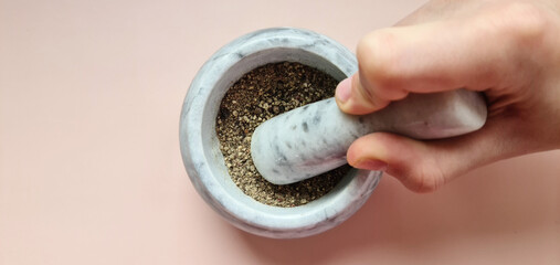 Grinding spices and herbs in cooking mortar