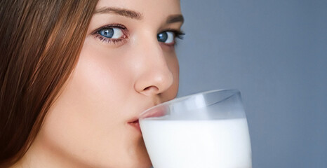 Happy young woman drinking milk or protein milk shake cocktail, healthy drink for diet and wellness...