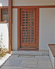 A house entrance with a natural wood and glass door. Athens, Greece.