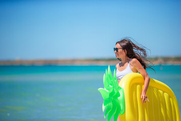 Fototapeta na wymiar Young woman splashing in waves on the beach