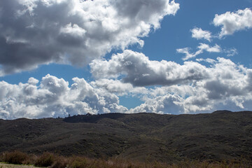 View of top of mountain with blue sky and clouds.
