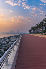 Panoramic view of business bay, downtown area of Dubai and two arab men take a walk on the promenade at cloudy day UAE