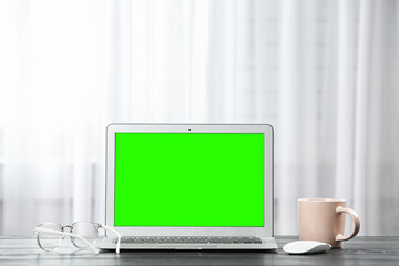 Laptop display with chroma key on desk in room. Comfortable workplace with modern computer