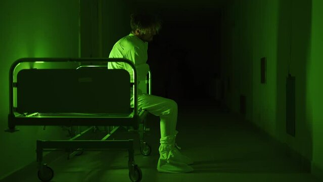 A mad male patient in straitjacket is going crazy in a mental hospital. Mentally ill man with psychic disorders and bipolar disease. Concept of paranoia or schizophrenia and madness or depression.
