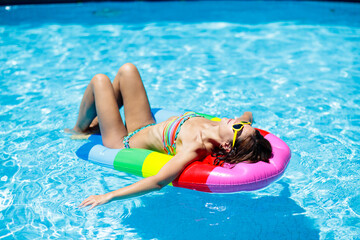 Woman in swimming pool on float. Female swimming.