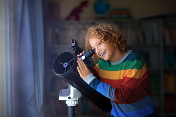 Little boy looking at stars through telescope