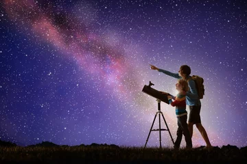 Fotobehang Man and child looking at stars through telescope © famveldman