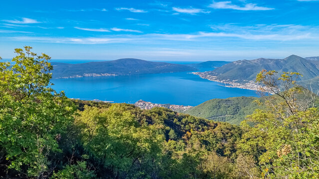 Panoramic view from mountain summit of Sveti Ilija on Kotor bay in sunny summer, Adriatic Mediterranean Sea, Montenegro, Balkans, Europe. Fjord winding along coastal town Tivat. Hiking in Dinaric Alps