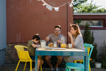 Family eats breakfast in the backyard