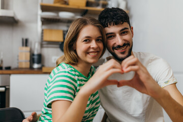 Fototapeta premium Affectionate couple makes a hart shape with their hands
