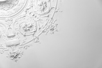 White gypsum bas-relief ceiling design elements in rococo style