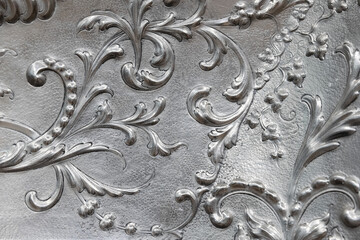 Shiny silver coinage, classic floral patterns, close up
